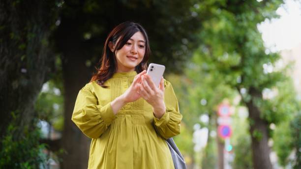 mulher grávida que usa o telefone inteligente na cidade - rush hour commuter on the phone tokyo prefecture - fotografias e filmes do acervo