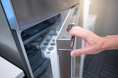 Male hand opening fridge or refrigerator door in kitchen