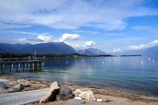 istock Boulders on a pebble beach and mountains on Lake Garda 1444757879