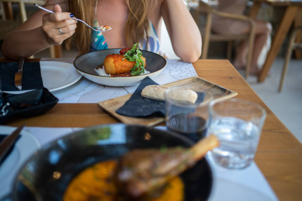istock A woman in a restaurant eats fried chicken meat with rice, sauce and arugula, unrecognizable person 1444760231