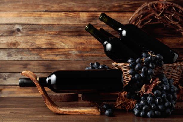 istock Red wine and blue grapes on an old wooden table. 1444761146