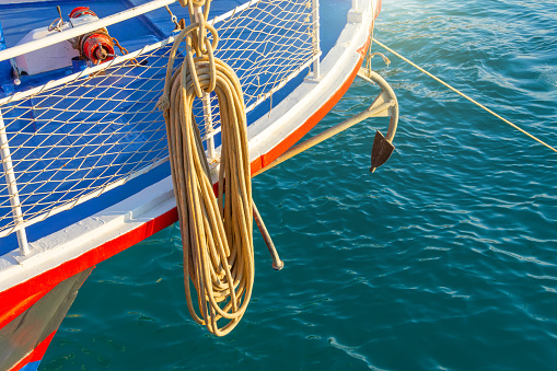 Rope and anchor on the bow of a pleasure boat in the sea bay