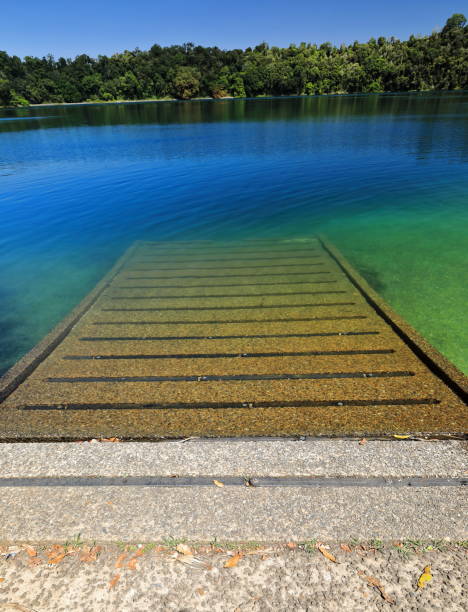 rampe de mise à l’eau de granulats entrant dans l’eau vert-bleu. lac eacham-australie-288 - boat launch photos et images de collection