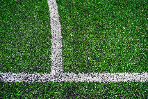 Soccer field. Synthetic grass sports field with white line shot from above. Football field marking.