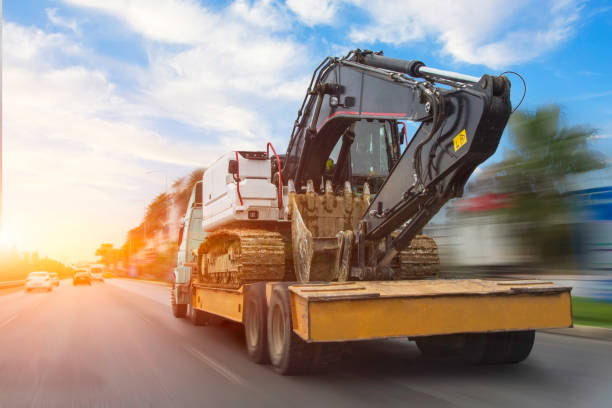 Transportation of a dirty excavator on a truck trailer after its work. Motion speed and blur effect on city highway, during sunset sky. Transportation of a dirty excavator on a truck trailer after its work. Motion speed and blur effect on city highway, during sunset sky construction truck bulldozer wheel stock pictures, royalty-free photos & images