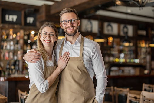 Two cheerful small business owners smiling and looking at the camera
