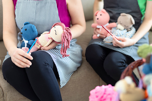 Knitted dolls in the hands of their creators
