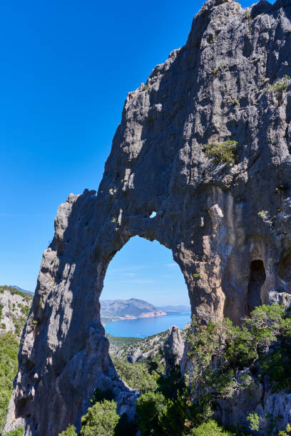 A natural limestone rock arch known locally as Arco di Lupiro or S'Archada Lupiru. Baunei municipality. Province of Nuoro. Sardinia. Italy.