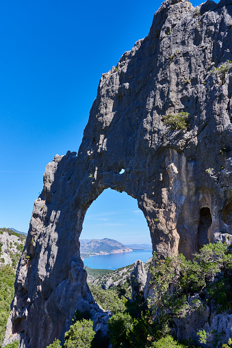 A natural limestone rock arch known locally as Arco di Lupiro or S'Archada Lupiru. Baunei municipality. Province of Nuoro. Sardinia. Italy.