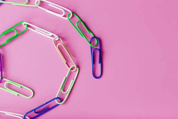 istock A chain of multi-colored paper clips on a pink background 1444790674