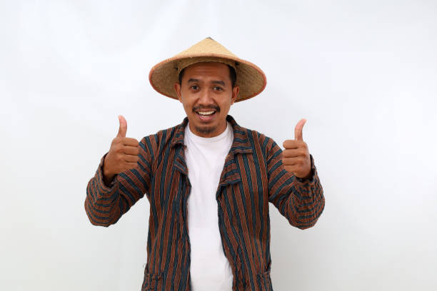 istock Joyful asian farmer standing while showing thumbs up. Isolated on white background 1444793735