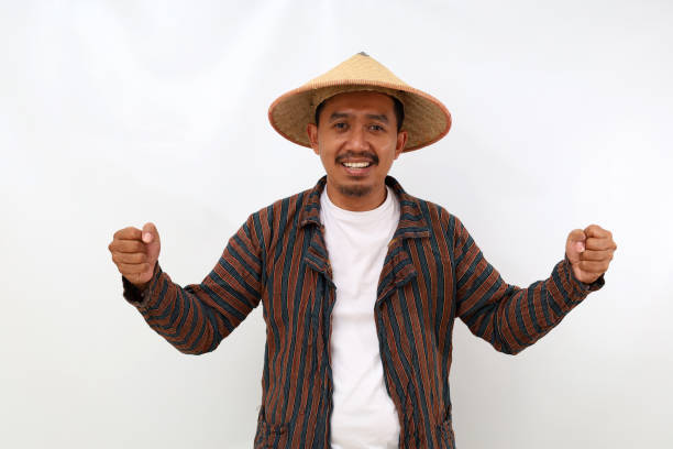 istock Succeed asian farmer standing with clenched hands and looking at the camera. Isolated on white background 1444793913