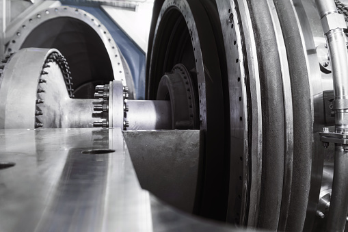 The rotor of a gas turbine compressor with a bolted coupling half. Internal elements of the disassembled turbine