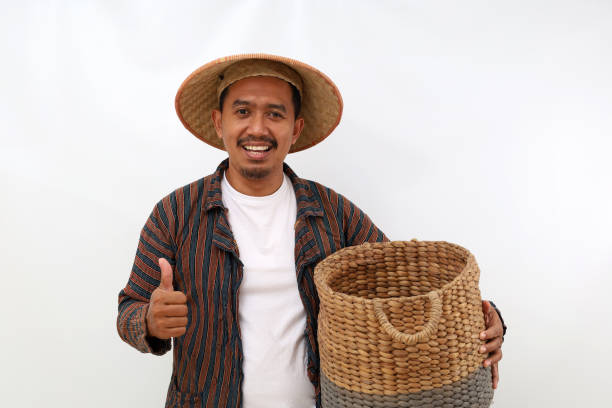 istock Happy asian farmer standing while holding an empty basket and showing thumbs up. Isolated on white background 1444794238