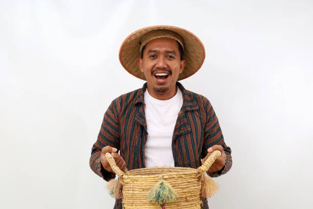 istock Happy asian farmer standing while holding an empty basket. Isolated on white background 1444795309