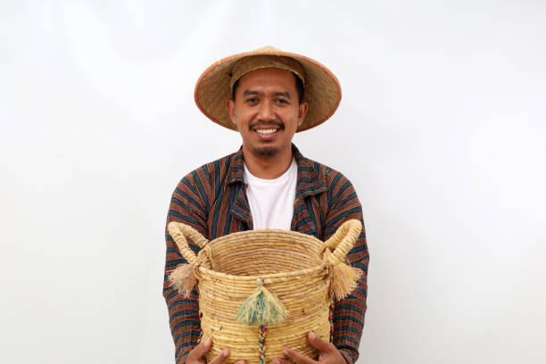 istock Happy asian farmer standing while holding an empty basket. Isolated on white background 1444795681