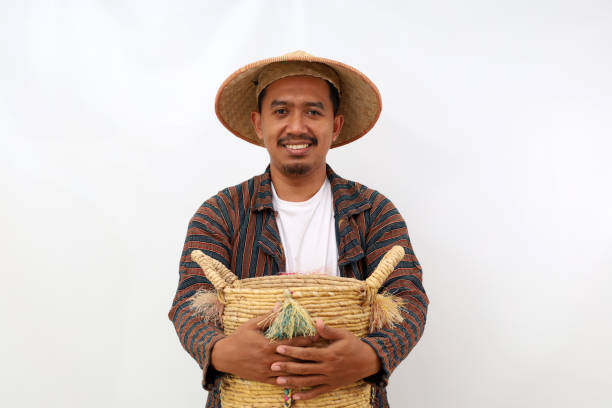 istock Happy asian farmer standing while holding an empty basket. Isolated on white background 1444795809