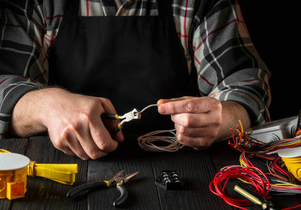 istock Master electrician cuts the wire with diagonal pliers. Working environment on workshop table 1444796291