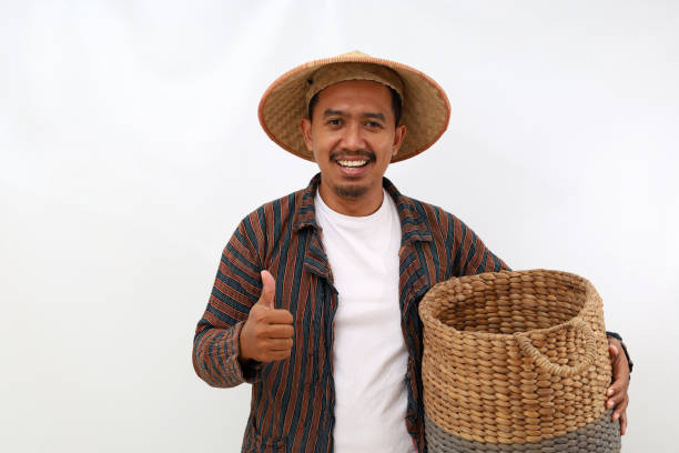 istock Happy asian farmer standing while holding an empty basket and showing thumbs up. Isolated on white background 1444797519