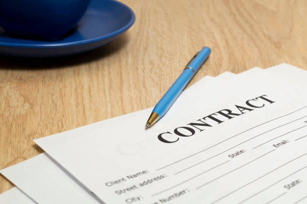 istock Contract with pen and notebook on wooden table. 1444797577