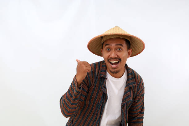 istock Happy asian farmer standing while presenting something beside him. Isolated on white background 1444800292