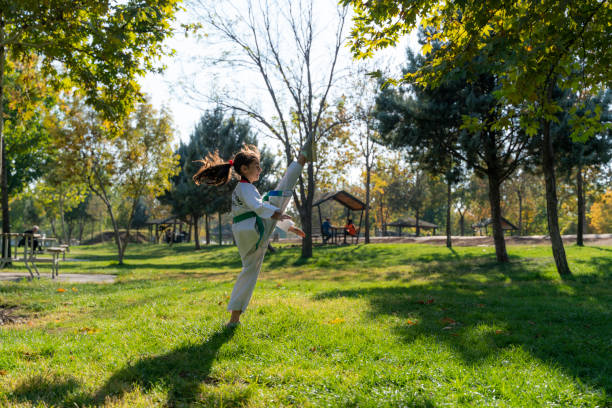 istock girl doing taekwondo training on grass in public park 1444805698