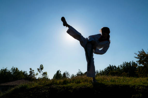 istock girl doing taekwondo training on grass in public park 1444806419
