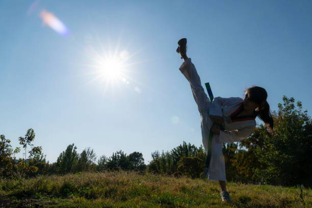 istock girl doing taekwondo training on grass in public park 1444806420