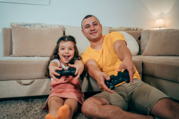 istock Father and daughter playing video games 1444808155