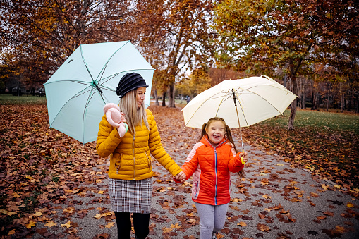 Mother and daughter spend time together on a rainy autumn day