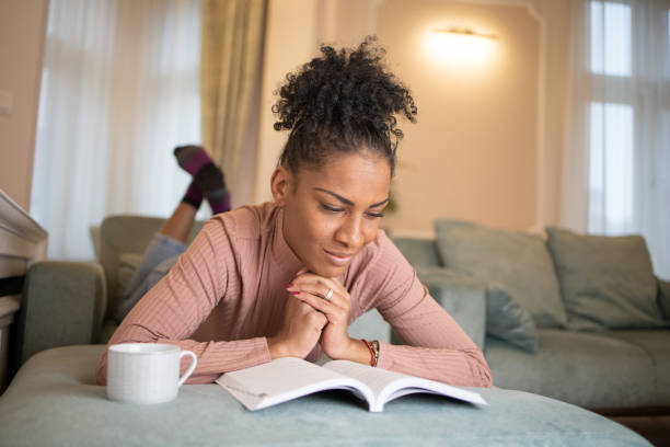istock Happy woman reading book at home 1444820722