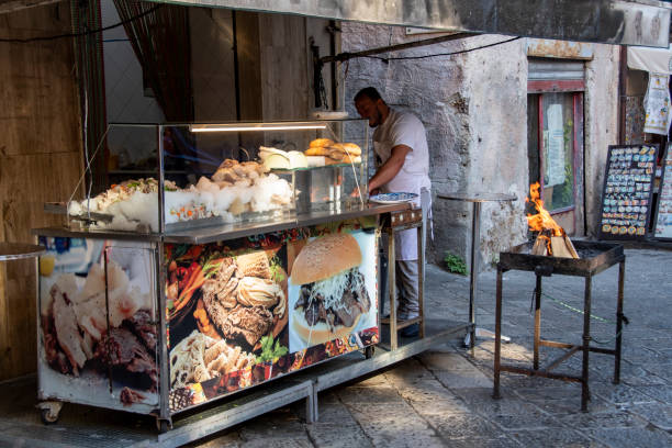 Palermo, Sicily, Italy - oct 7, 2022: in the small square of the Ballarò district a kiosk prepares and sells the typical sandwiches with spleen, a street food specialty of Palermo