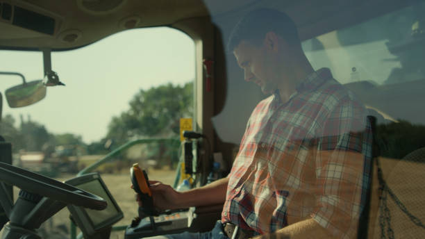 istock Driver farmer working machine automation in cockpit. Focused man control harvest 1444835443