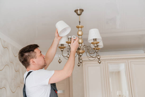 istock A male electrician changes the light bulbs in the ceiling light. 1444839094