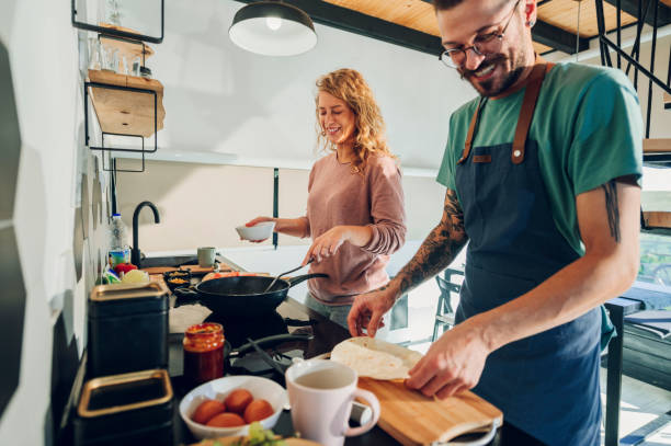 istock Young couple making breakfast together in the kitchen at home 1444840177