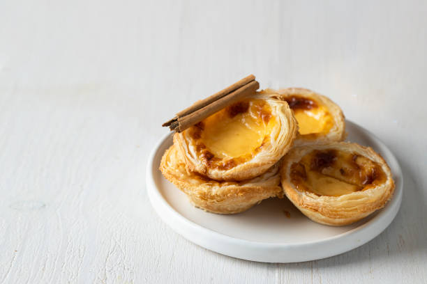 View of Pasteis de Belem a Portuguese egg custard tart pastry dusted with cinnamon. View of Pasteis de Belem a Portuguese egg custard tart pastry dusted with cinnamon. pasteis de belem stock pictures, royalty-free photos & images