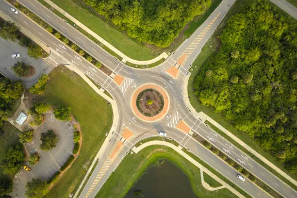 Photo of Aerial view of road roundabout intersection with moving cars traffic. Rural circular transportation crossroads