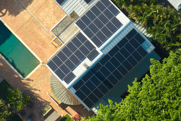 cara casa residencial estadounidense con techo cubierto con paneles solares fotovoltaicos para la producción de energía eléctrica ecológica limpia en áreas rurales suburbanas. concepto de hogar autónomo - solar panel energy solar energy house fotografías e imágenes de stock