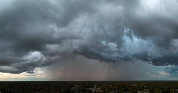 landscape of dark ominous clouds forming on stormy sky before heavy thunderstorm over rural town area - florida weather urban scene dramatic sky imagens e fotografias de stock