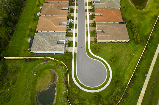 Aerial view of cul-de-sac at neighborhood street dead end with tightly packed homes in Florida closed living clubs. Family houses as example of real estate development in american suburbs.