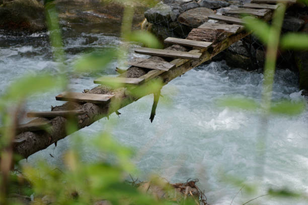 istock A makeshift wooden pedestrian bridge over a  gushing mountain stream 1444853895