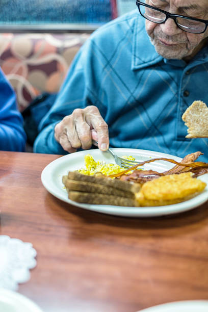 istock Elderly Senior Man Diner Eating Breakfast Scrambled Eggs 1444854851