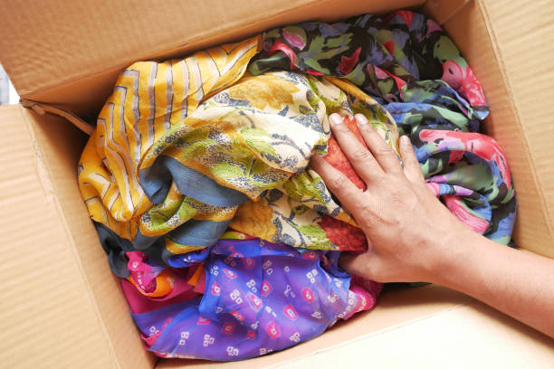 istock Donation box with donation clothes on a wooden table . 1444855578