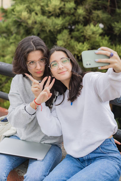 istock Two young female students taking a selfie in the park, with a laptop. 1444860319