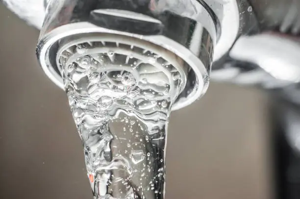 Photo of Frozen water stream from a tap Close-up. Aerator operation for saving water consumption.