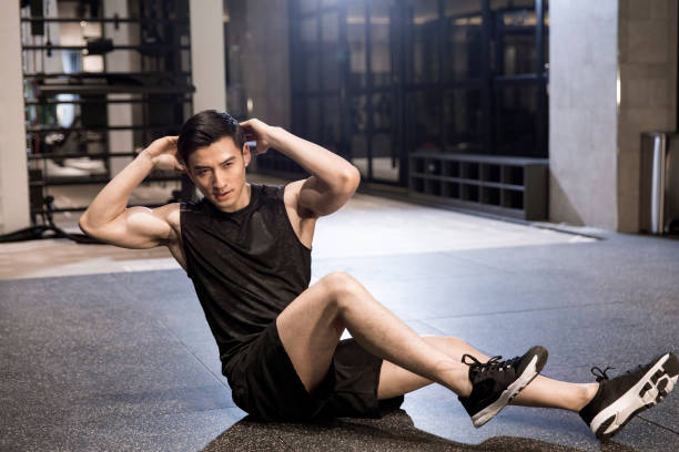 istock A young man doing side extension sit-ups on the gym floor 1444867405