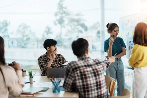 istock Young creative diverse group meeting and looking at project discuss or brainstorm business strategy with post note. Workshop for startup team in modern office. Happy workplace 1444867503