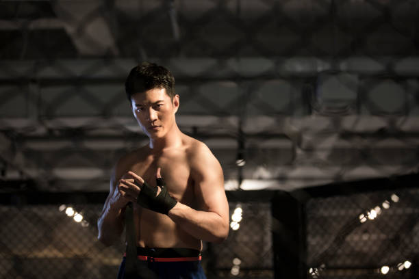 istock Wrapped rope Muay Thai hand-wrapping action, a robust topless young man who is doing pre-fighting preparations 1444867536