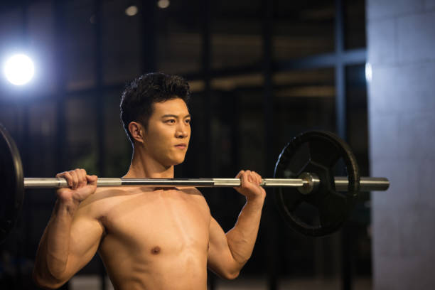 웨이트 트레이닝을 위해 바벨을 들어 올리는 청년 - body building weight training men flexing muscles 뉴스 사진 이미지