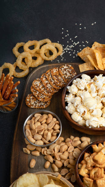istock Assortment of salty snacks on dark background. 1444869078